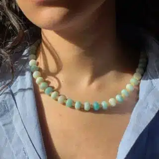 try on shot of the hand-beaded Citrine Skies Necklace No.01 in butter yellow agate stones blue stones A soft summer day, captured in stone. Inspired by the golden warmth of citrine sunsets and the tranquility of clear skies. Blends butter yellow and sky blue tones in a dreamy, refreshing palette. Handcrafted with butter yellow natural jade gemstones and finished with 925 sterling silver clasp. -Material: Natural jade stones - Length: 42 cm - 925 sterling silver clasp